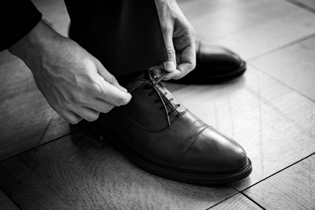Schuhe und Anzug, emotionale Hochzeitsmomente festgehalten.