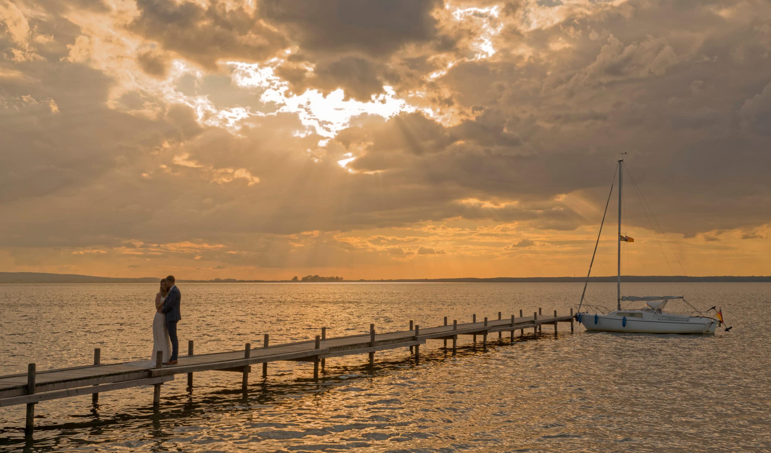 Hochzeitsfotograf Ammersee, romantisches Paar am Steg bei Sonnenuntergang am Ammersee.