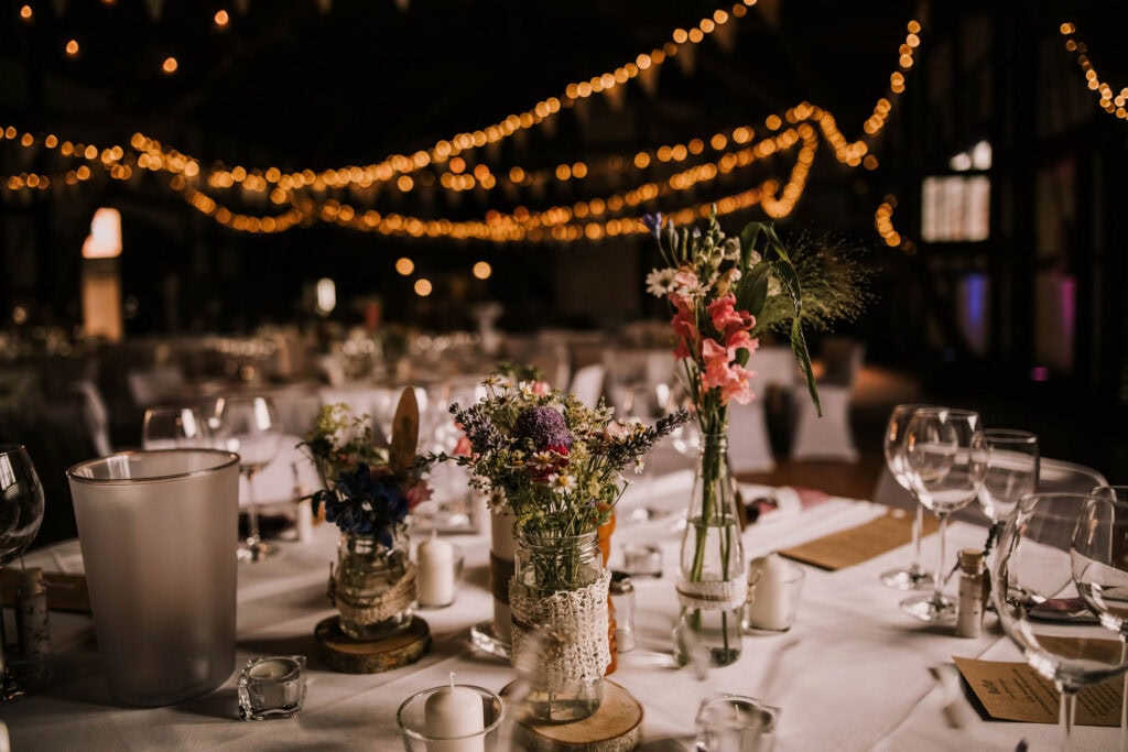 Elegante Hochzeitsdekoration mit Blumen und Lichterketten am Ammersee.