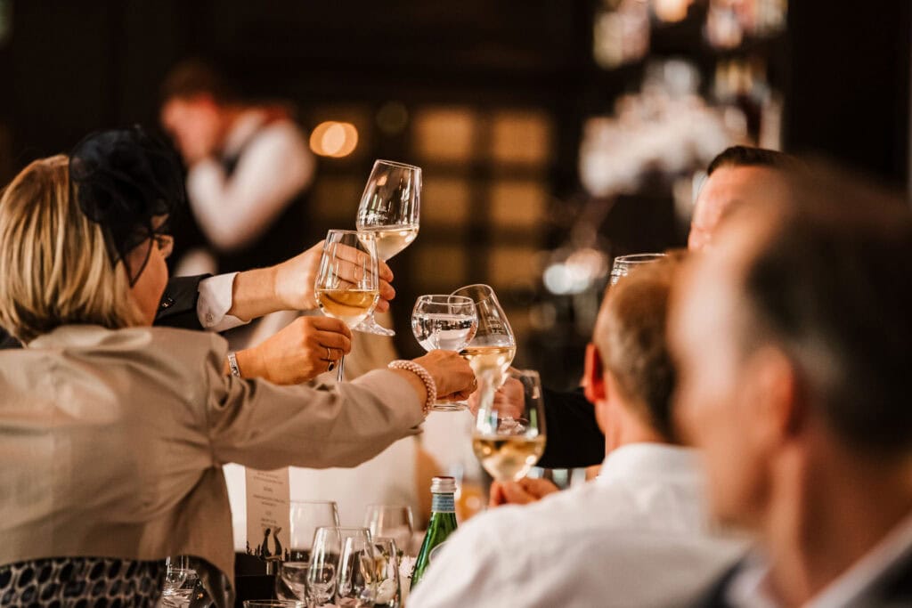 Gäste stoßen bei der freien Trauung am Ammersee mit Wein an.