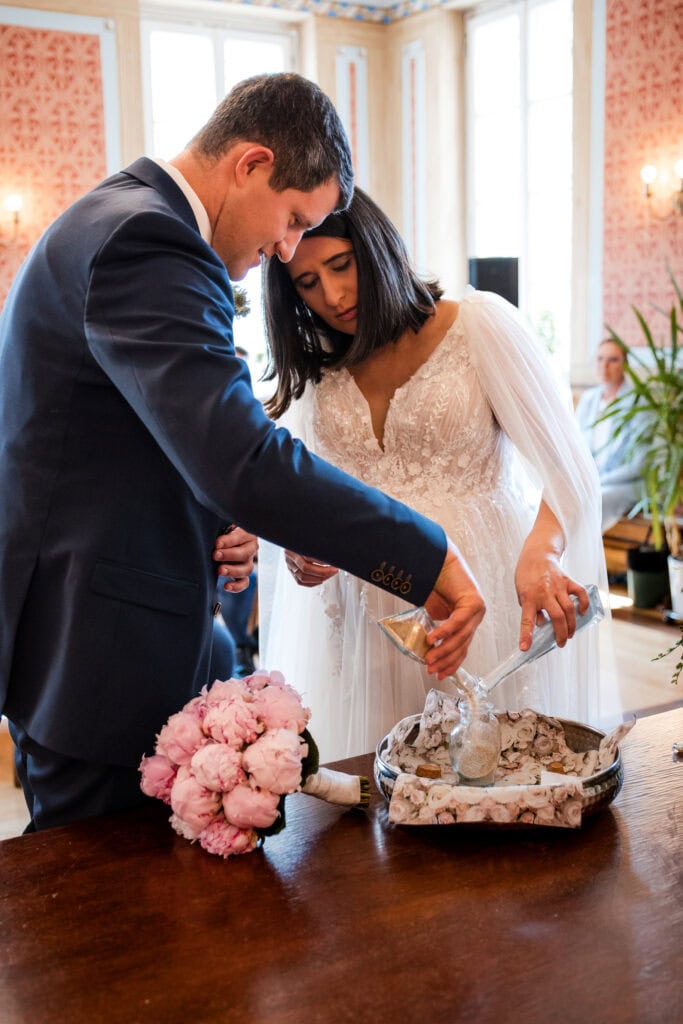 Braut und Bräutigam beim Sand Zeremonie, romantische Trauung in eleganter Location.