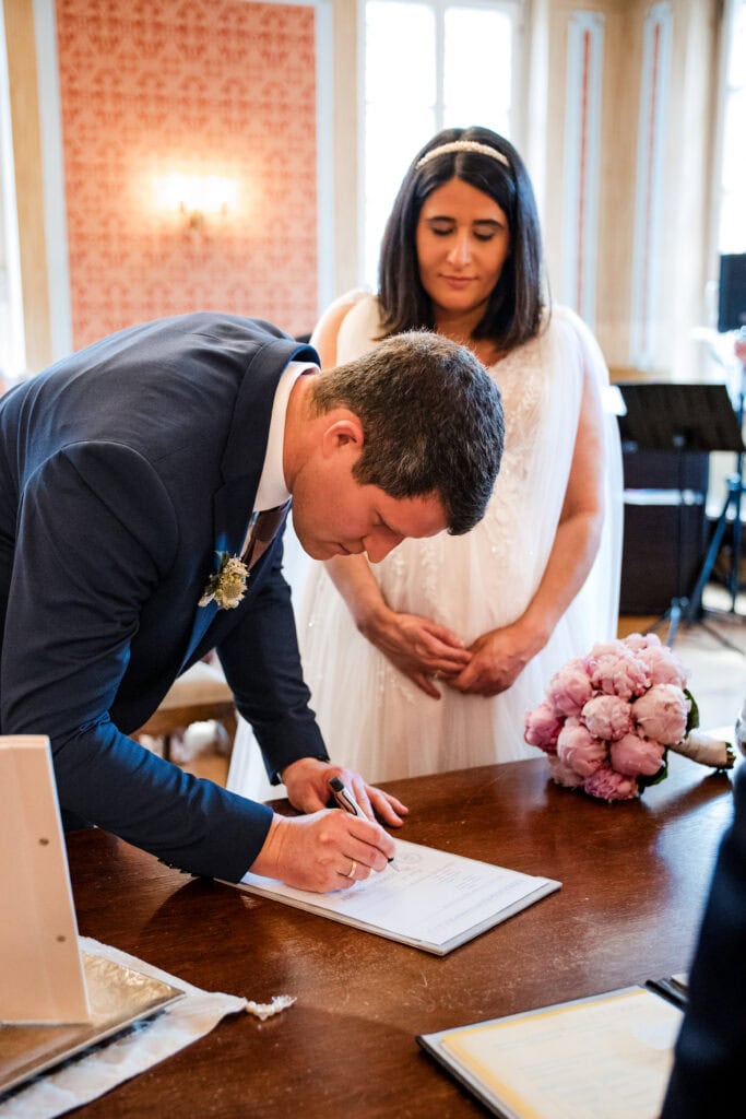 Brautpaar unterschreibt Heiratsurkunde bei Hochzeit in eleganter Location.