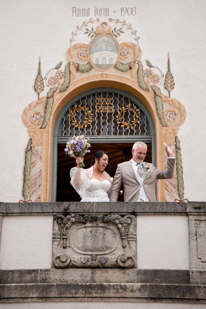 Braut und Bräutigam feiern Hochzeit vor historischer Kirche in Fürstenfeldbruck.