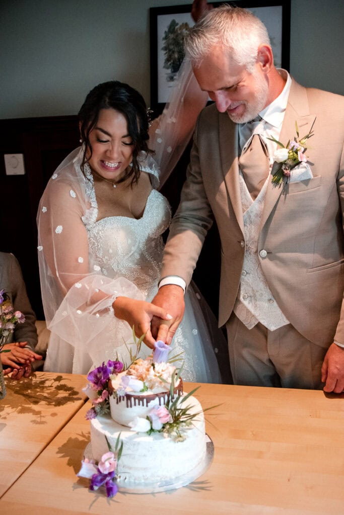 Braut und Bräutigam beim Anschneiden der Hochzeitstorte.