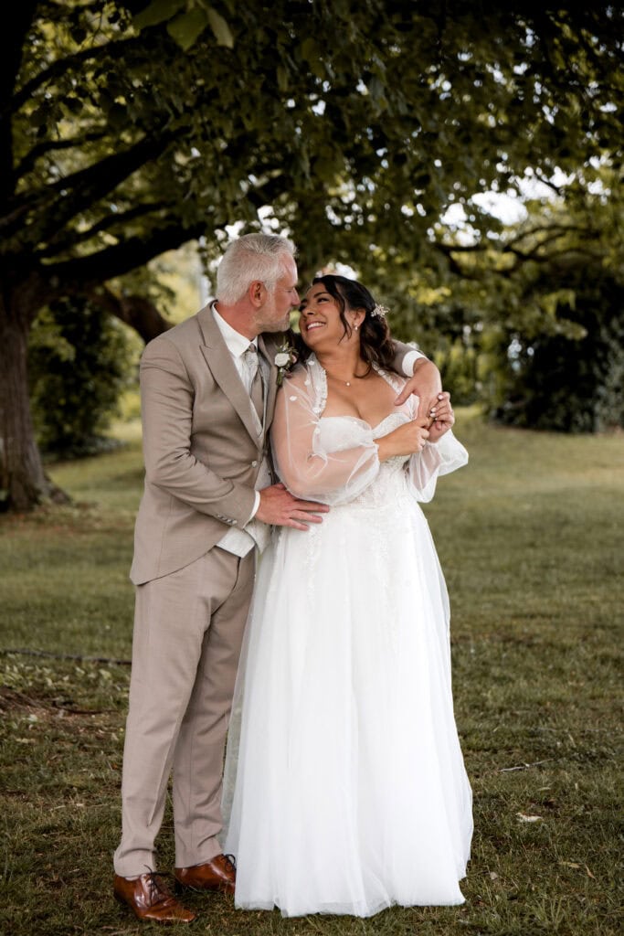 Braut und Bräutigam lachen im Park bei ihrer Hochzeit.