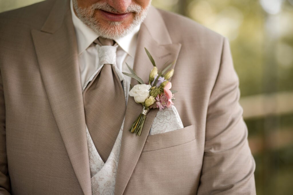Bräutigam in Hochzeitsanzug mit Blumenboutonnière.