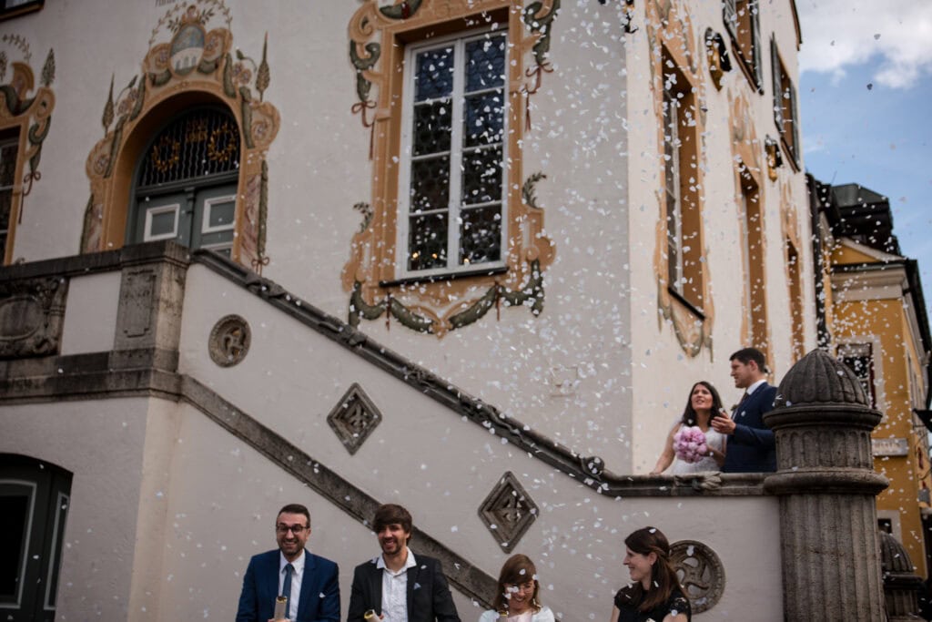 Brautpaar vor einem historischen Standesamt in Fürstenfeldbruck bei einer Hochzeit mit Konfetti
